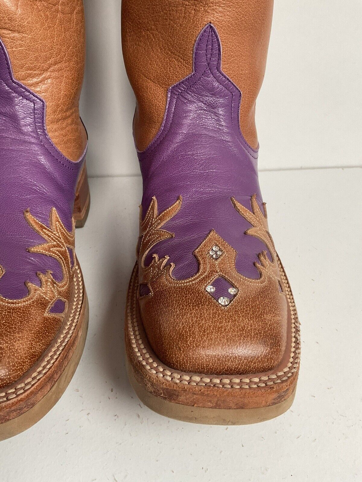 Custom purple cowgirl boots by Anderson Bean, size 7 B, featuring a crepe sole and elegant tooled wingtip overlay for a standout look.